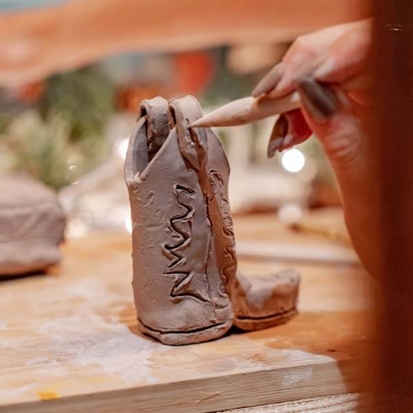 A cozy clay crafting session being shaped with a wooden tool using Sculpd Pottery Kit