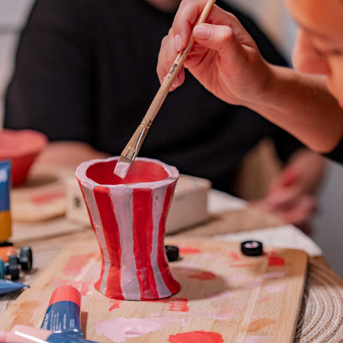A woman's hand painting a clay piece created using the Double Date Night Bundle