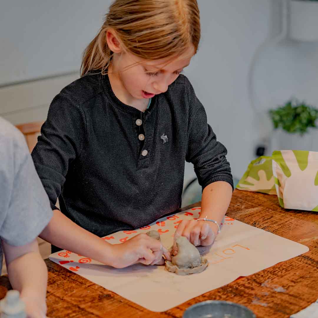A child sculpting her clay with Sculpd kids pottery kit
